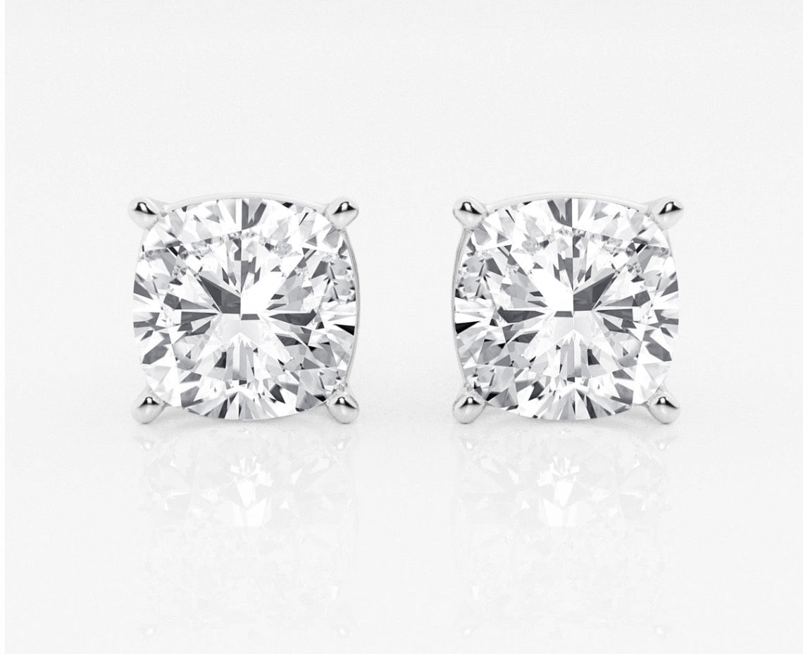 Front view of a pair of cushion lab diamond stud earrings set in white gold.