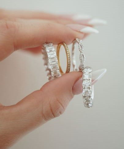 Woman holding 4 lab grown diamond rings.